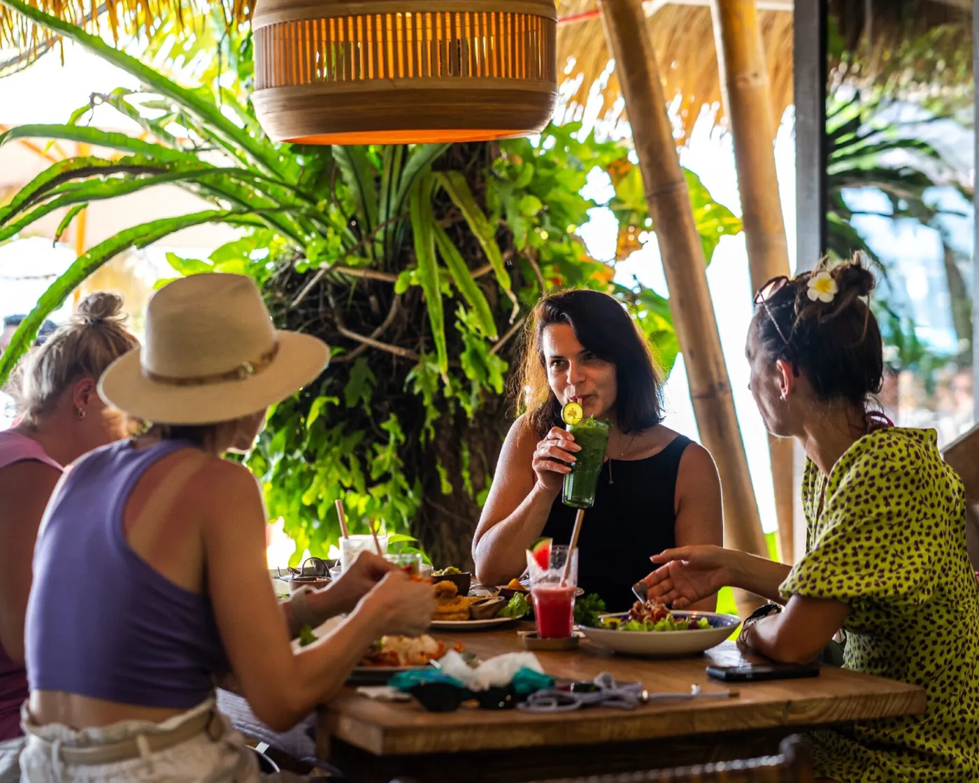 Friends laughing over drinks at Lilla Pantai, Sanur beach