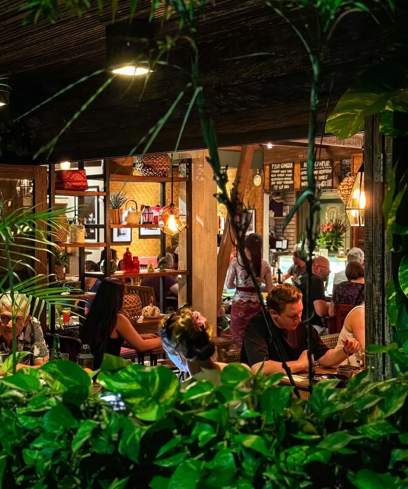 Guests dining in the lantern-lit garden at Lilla Warung